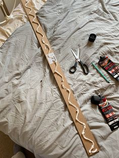 scissors, glue and other crafting supplies laid out on a bed