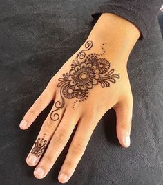 a woman's hand with henna tattoos on it