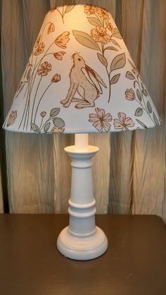 a white lamp sitting on top of a wooden table