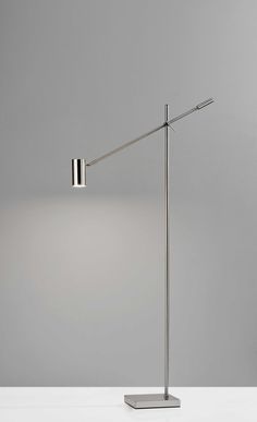 a lamp that is sitting on top of a white table next to a gray wall