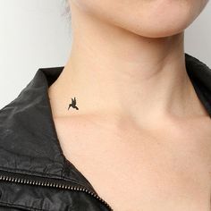 a woman with a small bird tattoo on her left side of her neck, looking at the camera