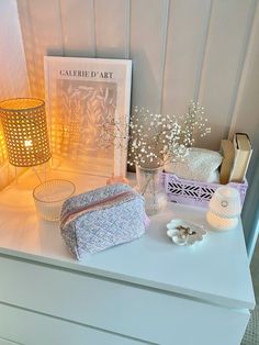 a white dresser topped with lots of items on top of it's side table