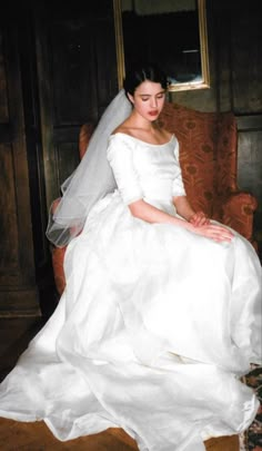 a woman in a wedding dress sitting on a chair