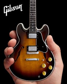 a person holding an electric guitar in their hand with the caption gibson guitars logo on it