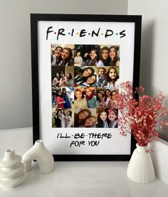 a white vase with red flowers next to a black and white photo frame that says friends