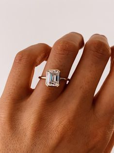 a woman's hand with an engagement ring on her finger, showing the center stone