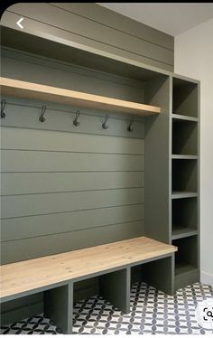 an empty bench in the middle of a walk - in closet with hooks on it