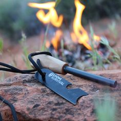 a knife sitting on top of a rock next to a fire