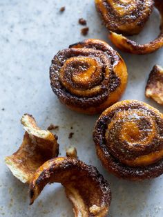 cinnamon buns with powdered sugar on them sitting on a counter top, ready to be eaten