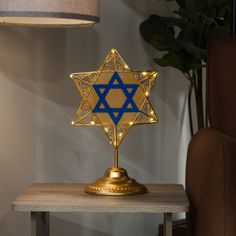 a star of david on a table with a lamp