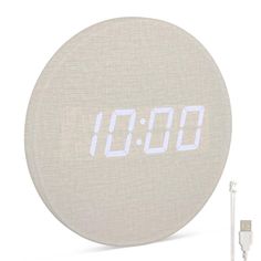 an alarm clock sitting next to a charger and plugged in power cord on a white background