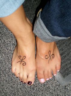 two people with tattoos on their feet and one has a bow tattoo on the foot