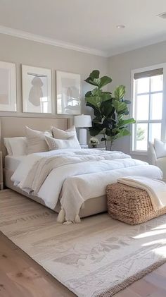 a large white bed sitting in a bedroom next to a window with potted plants