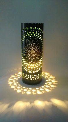 a lit up vase sitting on top of a white surface with lots of light coming from it