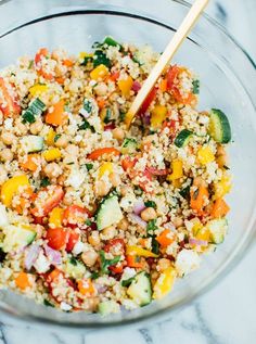 a glass bowl filled with couscous and vegetables