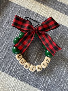 a christmas ornament with the words on it and a red ribbon tied around it