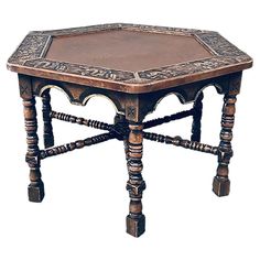 an old wooden table with ornate carvings on the top and bottom, sitting against a white background