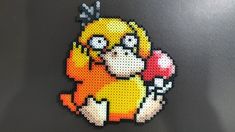 a close up of a piece of art made out of perler beads with an image of a cartoon character