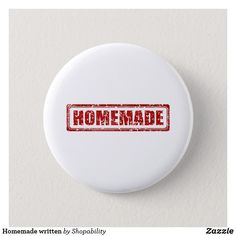 a white button with the word homemade written on it in red ink, against a white background