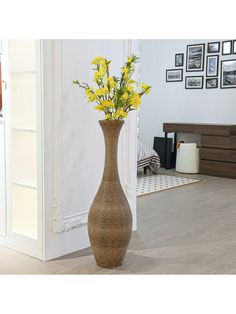 a tall vase with yellow flowers in it