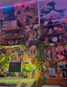 a desk with a computer on it in front of a wall full of anime pictures