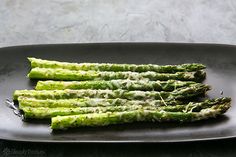 asparagus spears on a black plate ready to be cooked in the oven for dinner