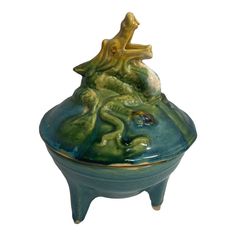 a ceramic container with a woman sitting on top of it