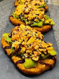 three pieces of bread with various toppings on them sitting on top of a table