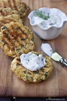 two crab cakes on a wooden table with a cup of coffee in the back ground