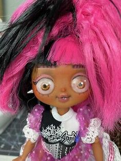 a close up of a doll with pink and black hair on it's head