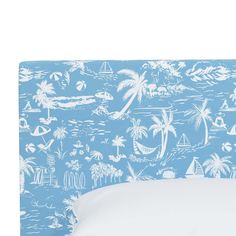 a blue and white headboard with palm trees, boats, and sailboats on it