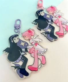 two keychains with cartoon characters on them, one is pink and the other is blue