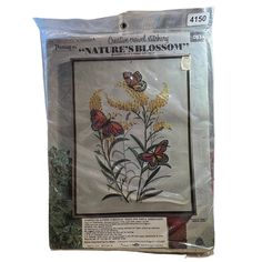 the cross stitch kit is in plastic and has yellow flowers with butterflies flying around it