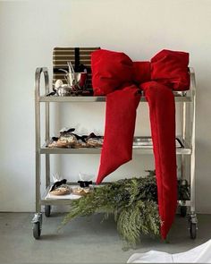 a metal cart with red bows on it and some shoes sitting on top of it