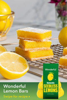 lemon bars stacked on top of each other next to sliced lemons and a bowl of flowers