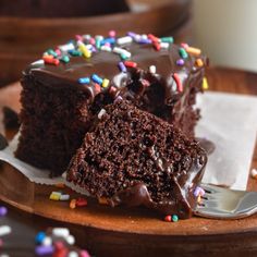 a piece of chocolate cake with sprinkles on a plate and a fork