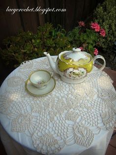 a tea set on top of a white table cloth