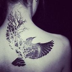 the back of a woman's neck with a tree and bird tattoo on it