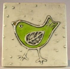 a green bird is sitting on a white square tile with drops of water around it