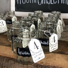 there are many mason jars on the table with tags attached to them that read 4, 5, and 8