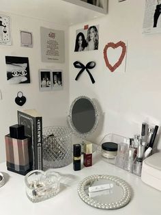 a white vanity topped with lots of makeup and personal care items next to a mirror