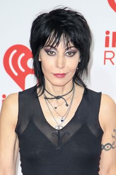 a woman with black hair and piercings posing for the camera