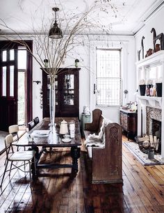 a living room filled with furniture and a fire place next to a fireplace on top of a hard wood floor