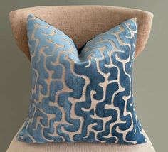 a blue and beige pillow sitting on top of a chair