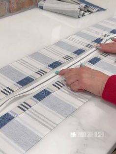 a woman is using scissors to cut strips of fabric