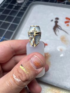 a person holding up a ring with a cross on it