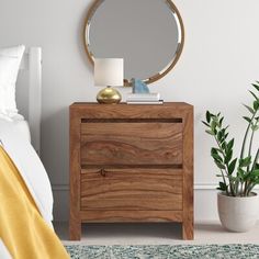 a bedroom scene with focus on the nightstand and mirror over the bed, along with a potted plant