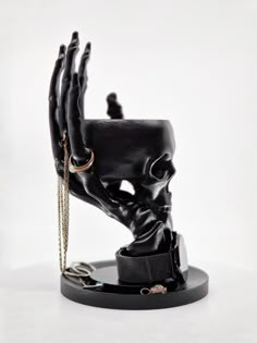 a black statue with chains on it's arm and hands in the shape of a hand