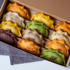 a box filled with lots of different flavored pastries on top of a table