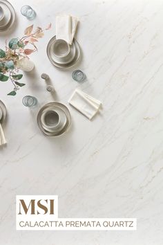 the table is set with silver dishes and place settings